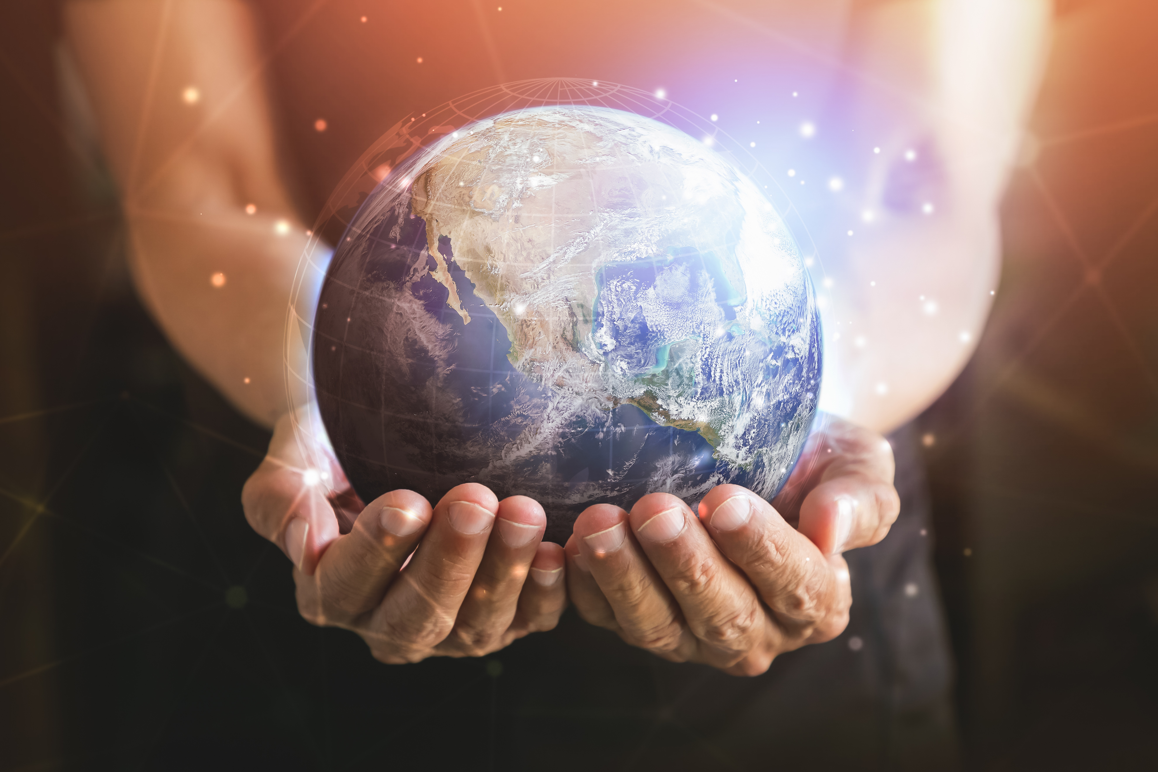 Hands holding a glowing globe representing global community